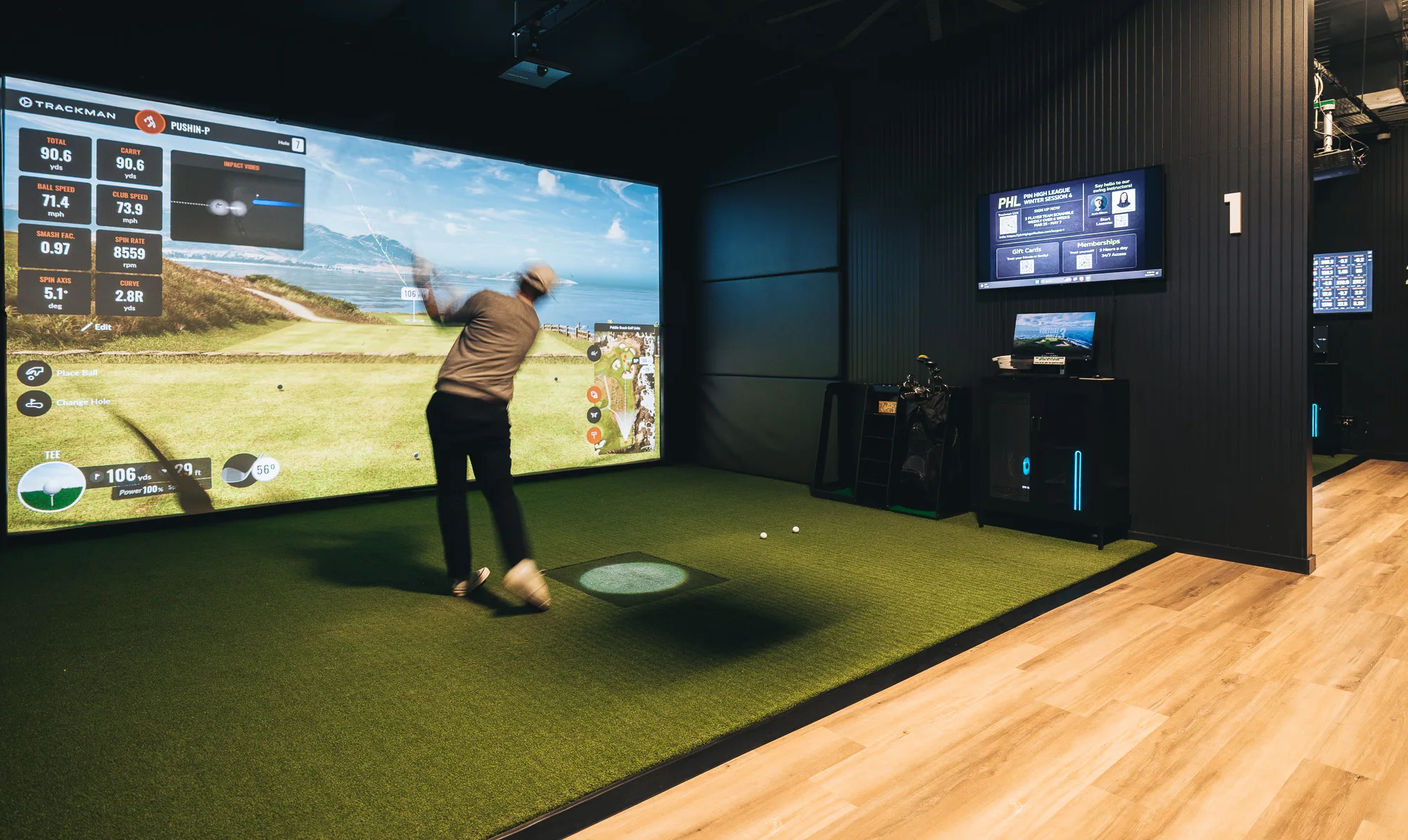 Interior of Pin High Golf Suites showing premium golf simulator bay with large projection screen