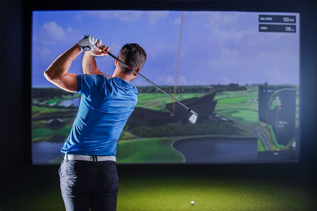 Golf instructor using TrackMan data to analyze a student's swing at Pin High Golf Suites